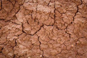Close up image of brown dry soil texture. Abstract pattern of red-hot cracked clay. Lifeless desert background.
