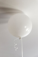 Balloons filled with helium hang from the ceiling of the room.