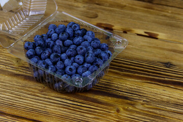 Fresh blueberry in plastic box on a wooden table