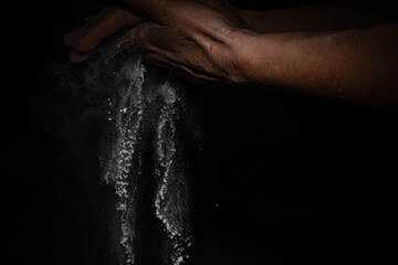 explosión de polvo blanco harina con manos fondo negro con espacio para texto