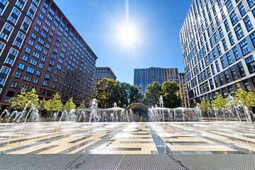 downtown plaza in modern city landmark with dancing fountain and patio area against blue sky...
