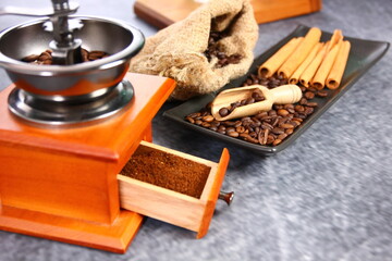 roasted coffee beans on brown ceramic plate with grinded coffee in coffee grinder