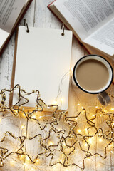 Christmas and New Year festive background.to do list on winter holidays. Shopping list, cup of tea and  garland.Winter mockup. Plans for Christmas. Winter books.Winter mood
