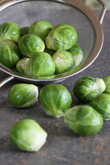 Fresh brussel sprouts in a kitchen sieve.