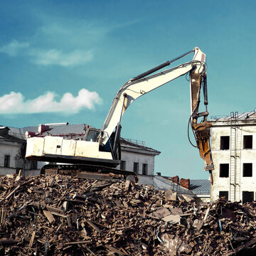 excavator demolishing a brick building. Machinery Demolishing Building