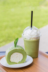 Green Tea Roll Cake With Tea Leaves and Iced Green Tea With Milk. Green Tea Roll Cake, Japanese Dessert Style With White Vanilla Cream Inside