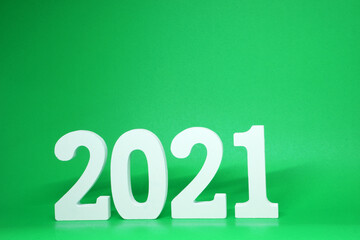 Happy new year 2021 , 2021 number wooden object on green background and copy space - green new year celebrate concept 