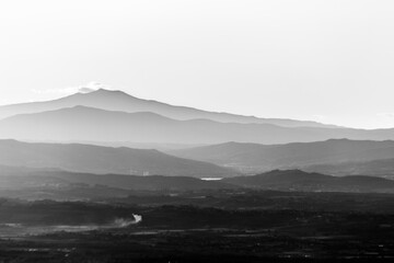 Mist and smoke between valley and layers of mountains and hills at dusk, in Umbria (Italy)