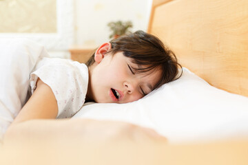 Obraz na płótnie Canvas girl is sleeping on clean white soft bed