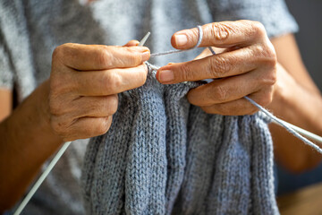 Old woman's hands are knitting
