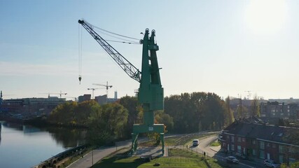Aerial, pov, a green construction crane by a canal, Gent, Belgium