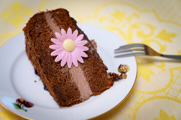 Chocolate cream cake with pink flower.