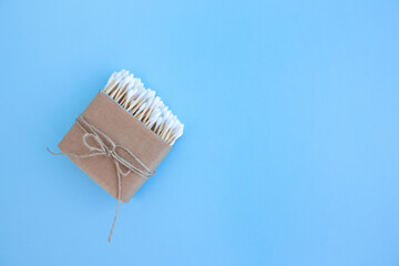 Mockup image of bamboo cotton buds in paper box, bound with flax or hemp cord on blue background. Zero waste and sustainable lifestyle concept, eco friendly bathroom essentials. Copyspace