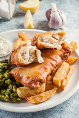Fish in beer batter and chips with green pea and tartar sauce