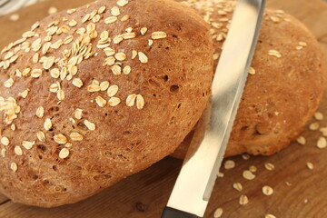 two fresh farmer's breads with a knife