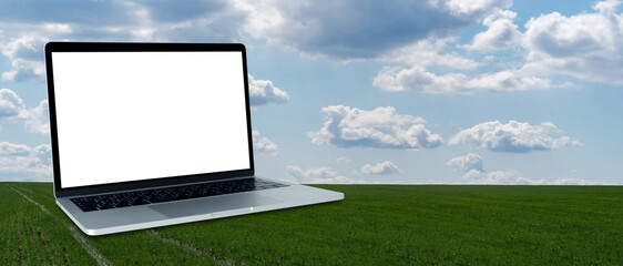 Laptop with white screen on a background of agricultural field. Smart farming and precision agriculture 4.0	