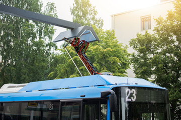 Electric bus at a stop is charged by pantograph