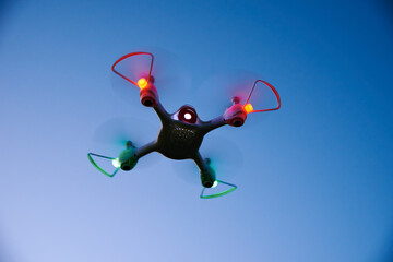 Toy drone quad copter against sunset sky