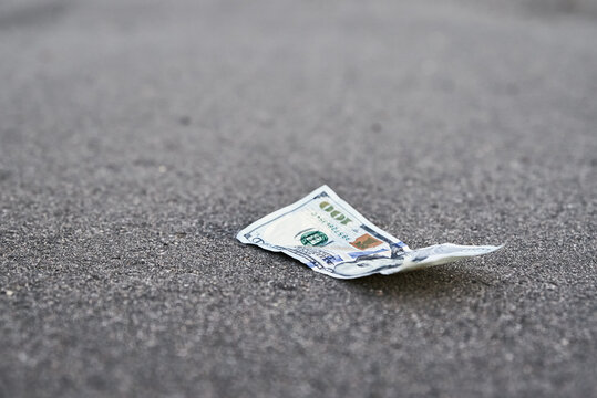 Lost Money On The Road. One Hundred Dollar Bill On The Pavement