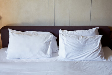 Fototapeta na wymiar White pillows and blanket on bed
