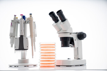 microscope, petri dishes and pipette stand by microbiological laboratory