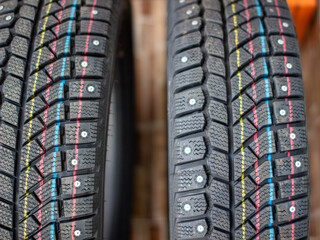 New, black winter car tires with spikes.