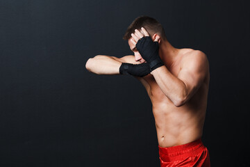 Sportsman muay thai man boxer stance ad elbow punch at black background