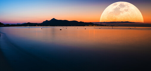 Fantastic landscape with a giant moon against the backdrop of a seascape