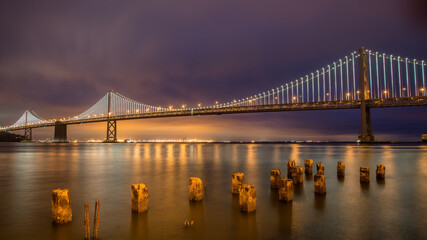 Naklejka na ściany i meble Panoramic view of San Francisco Bay bridge at night, California, United States