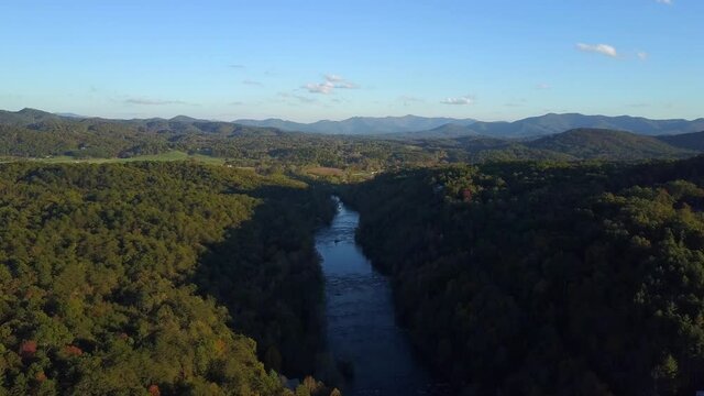 Aerial, pov, a river runs through early autumn forest, North Carolina, USA