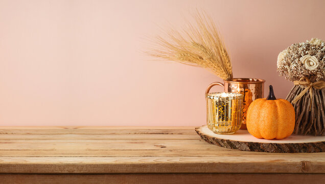 Autumn season concept with pumpkin decor and candle on wooden table. Halloween or Thanksgiving greeting card.