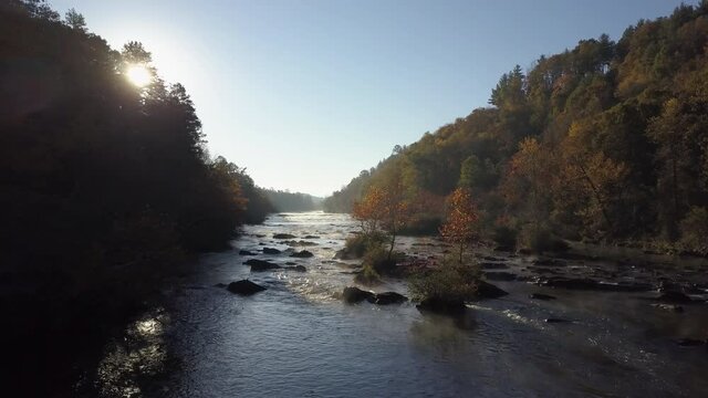Aerial, pov, autumn landscape with a river and a lens flare, North Carolina, USA