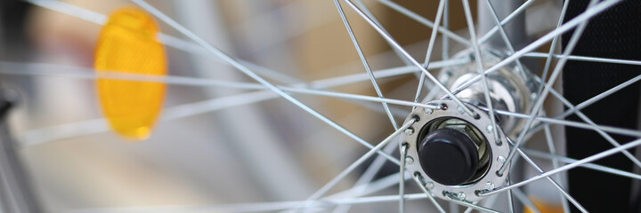 Close-up of spokes on clean shiny bicycle standing outside on street. Part of bike. Detail or...