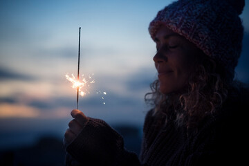 Celebration and hope future concept with beautiful woman portrait with fired sparkler in the dark...