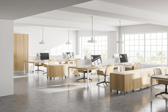 Modern white open space office corner with wooden tables
