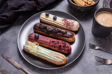Set of different eclair cakes on dark backgrouns