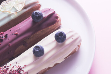 Set of different eclair cakes on pink background
