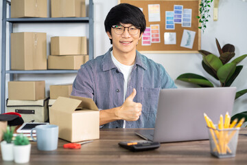 Asian man entrepreneur startup small business entrepreneur SME freelance man working with box to online marketing packaging and delivery scene at home office, onlinebusiness seller concept.