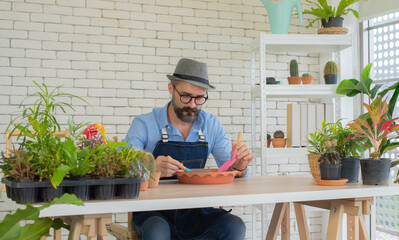 Elderly men Dignified dressing Happy with hobbies Sitting with a big desk Planting trees in the house