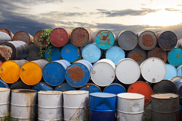 Fototapeta premium Old metal chemical tanks at sunset sky, dirty oil steel drums, environment, chemical disposal