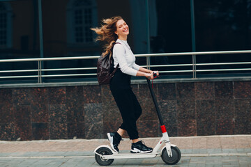 Young woman with electric scooter at the city © primipil