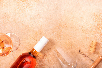 Rose wine glass with bottle on the beige table. Rosado, rosato or blush wine tasting in wineshop,...
