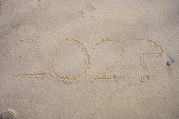 writing in the sand year 202? as a concept when can we go on vacation insecurity because of corona