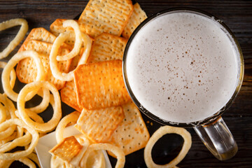 glass of beer  and onion rings and a cracker , drink with snacks, top view,