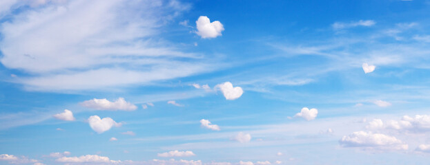 Clouds with heart shape form flying on blue panoramic sky. Romantic, love symbol background