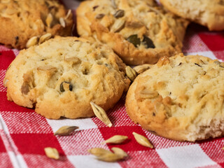 Oatmeal cookies with husk whole oats on red kitchen gingham checkered cotton fabric on table in farm-style.