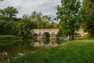 Fototapeta na wymiar Mittelalterliche Bogenbrücke über die Altmühl in Pfünz bei Eichstätt mit grünem Ufer und Bäumen in der Landschaft