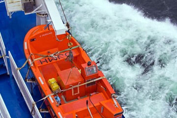 BALTIC SEA, FINLAND - OCTOBER 10, 2015.A top view on orange lifeboat on the deck of a ship sailing...
