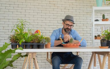 Elderly men Dignified dressing Happy with hobbies Sitting with a big desk Sitting and watching the trees that I planted