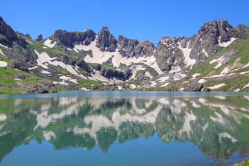 Fototapeta premium a glacial lake in mountains, winter season, cold weather and blue sky, snowy mountains 